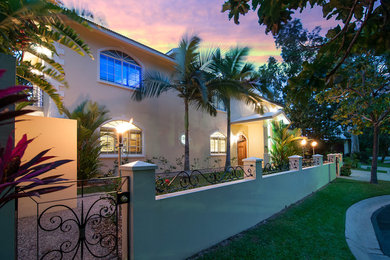Expansive tropical two-storey stucco beige exterior in Cairns with a hip roof.