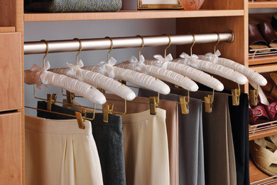 Example of a large classic gender-neutral walk-in closet design in Cedar Rapids with open cabinets and medium tone wood cabinets