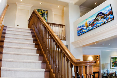 エドモントンにある高級な中くらいなおしゃれな直階段 (木の蹴込み板、木材の手すり) の写真
