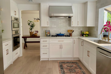 Example of a large transitional l-shaped vinyl floor and beige floor eat-in kitchen design in Los Angeles with a single-bowl sink, shaker cabinets, white cabinets, quartz countertops, gray backsplash, porcelain backsplash, stainless steel appliances, no island and white countertops