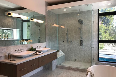 Example of a large trendy master gray tile and pebble tile marble floor and gray floor bathroom design in Los Angeles with beaded inset cabinets, dark wood cabinets, gray walls, a vessel sink, marble countertops, a hinged shower door and gray countertops