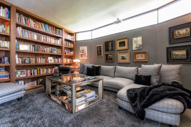 Ejemplo de biblioteca en casa cerrada ecléctica de tamaño medio sin chimenea y televisor con paredes grises y moqueta