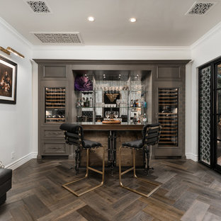 Inspiration for a mediterranean galley breakfast bar in Phoenix with recessed-panel cabinets, grey cabinets, mirror splashback, dark hardwood flooring and brown floors.