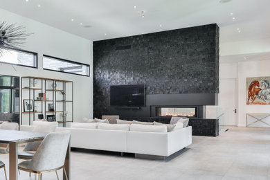 モントリオールにあるラグジュアリーな広いモダンスタイルのおしゃれなLDK (白い壁、セラミックタイルの床、両方向型暖炉、木材の暖炉まわり、壁掛け型テレビ、グレーの床、板張り壁) の写真