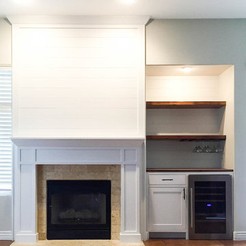 White shiplap fireplace and minibar with floating shelves and wine fridge