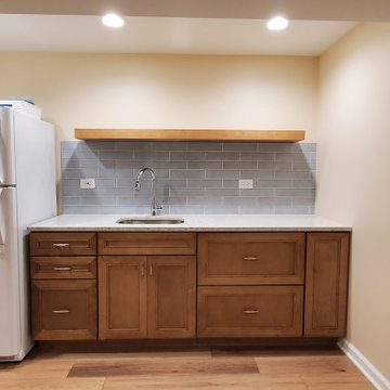 Finished basement kitchenette with floating shelf and quartz countertop.