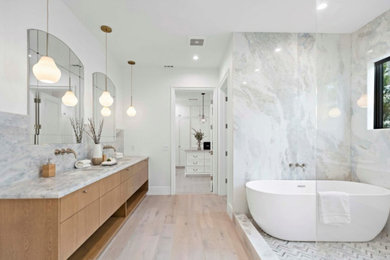 Inspiration for a mid-sized timeless master gray tile and marble tile double-sink double shower remodel in Los Angeles with flat-panel cabinets, light wood cabinets, an undermount tub, marble countertops, gray countertops and a built-in vanity