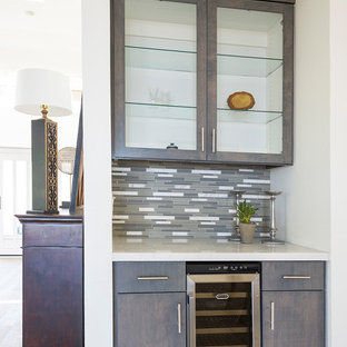 オレンジカウンティの小さいコンテンポラリースタイルのおしゃれなウェットバー (無垢フローリング、ベージュの床、シンクなし、フラットパネル扉のキャビネット、グレーのキャビネット、クオーツストーンカウンター、マルチカラーのキッチンパネル、ボーダータイルのキッチンパネル) の写真