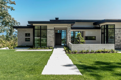 Large trendy beige two-story stone exterior home photo in Vancouver with a shingle roof