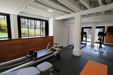 Example of a mid-sized transitional black floor and exposed beam multiuse home gym design in Baltimore with white walls