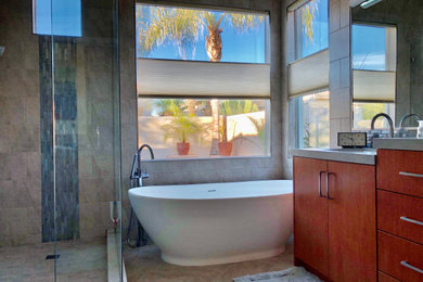 Inspiration for a mid-sized mid-century modern master multicolored tile and porcelain tile multicolored floor, double-sink and porcelain tile bathroom remodel in Phoenix with flat-panel cabinets, medium tone wood cabinets, a bidet, white walls, an undermount sink, tile countertops, a hinged shower door, gray countertops and a freestanding vanity