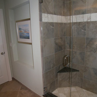 Cette photo montre une salle de bain chic de taille moyenne avec un placard à porte persienne, des portes de placard beiges, une baignoire encastrée, un carrelage de pierre, un mur bleu, un sol en carrelage de porcelaine, un lavabo encastré et un plan de toilette en granite.