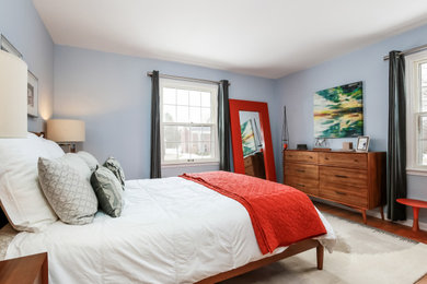 グランドラピッズにある中くらいなミッドセンチュリースタイルのおしゃれな主寝室 (青い壁、無垢フローリング、暖炉なし、茶色い床、アクセントウォール) のレイアウト
