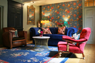 Photo of a medium sized eclectic enclosed living room feature wall in Other with green walls, light hardwood flooring and wallpapered walls.