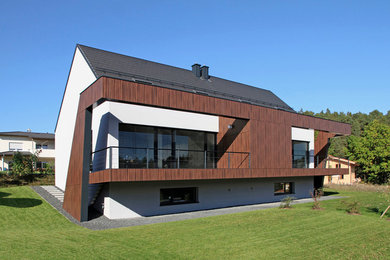 This is an example of a mid-sized contemporary two-storey stucco grey exterior in Nuremberg with a gable roof.