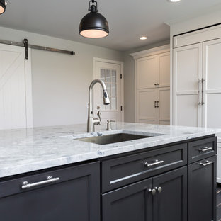 Large country kitchen pantry in New York with an undermount sink, recessed-panel cabinets, white cabinets, granite benchtops, white splashback, porcelain splashback, panelled appliances, porcelain floors and with island.