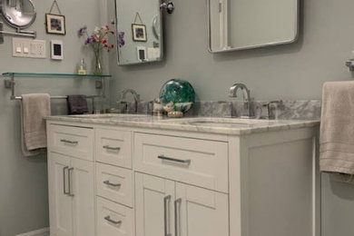 Small transitional master marble floor and double-sink drop-in bathtub photo in Toronto with white cabinets, a one-piece toilet, green walls, marble countertops, a hinged shower door and a freestanding vanity