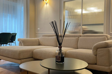 Immagine di un grande soggiorno contemporaneo con pareti beige, parquet chiaro e boiserie