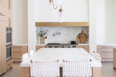 Inspiration for a large contemporary u-shaped concrete floor and gray floor kitchen remodel in Austin with flat-panel cabinets, light wood cabinets, marble countertops, white backsplash, stone slab backsplash, paneled appliances, an island and white countertops