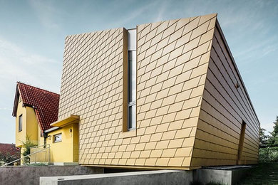 Modernes Einfamilienhaus mit Metallfassade, beiger Fassadenfarbe, Pultdach und Blechdach in Sonstige