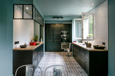 Mid-sized traditional u-shaped open plan kitchen in Paris with an undermount sink, green cabinets, wood benchtops, white splashback, cement tile splashback, ceramic floors and no island.