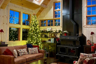 This is an example of a mid-sized country open concept living room with beige walls, dark hardwood floors, a wood stove, a metal fireplace surround, brown floor, wood and wood walls.
