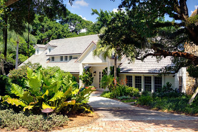 Example of a large classic white three-story wood exterior home design in Miami with a shingle roof
