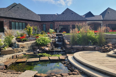 This is an example of a huge traditional full sun backyard concrete paver and metal fence landscaping in St Louis.