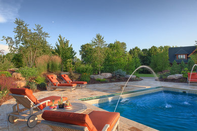 Inspiration for a timeless backyard tile and rectangular pool fountain remodel in Minneapolis