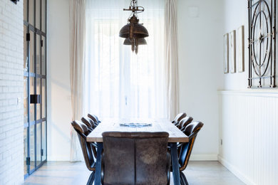 Idee per una sala da pranzo industriale di medie dimensioni con pareti bianche, pavimento in gres porcellanato, pavimento grigio e boiserie