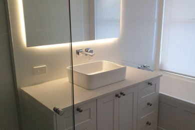 Kids bathroom in Gold Coast - Tweed with shaker cabinets, white cabinets, white tile, engineered quartz benchtops and white benchtops.