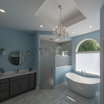 Traditional master bath utilizing frosted and clear glass to allow for needed pr