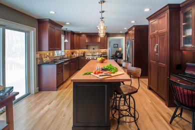 Large traditional l-shaped eat-in kitchen in Boston with an undermount sink, shaker cabinets, dark wood cabinets, quartzite benchtops, multi-coloured splashback, stone tile splashback, stainless steel appliances, light hardwood floors, with island, brown floor and black benchtop.