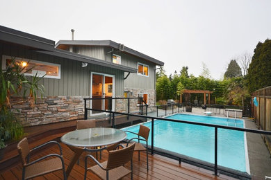 Example of a large trendy backyard rectangular pool design in Vancouver with decking