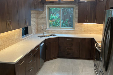 Enclosed kitchen - small transitional u-shaped enclosed kitchen idea in Austin with flat-panel cabinets, dark wood cabinets and quartz countertops