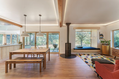 Living room - contemporary open concept light wood floor and exposed beam living room idea in Portland with white walls, a wood stove and no tv