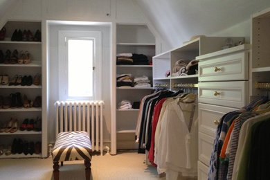 Large traditional gender-neutral walk-in wardrobe in Philadelphia with recessed-panel cabinets, white cabinets, carpet and brown floor.