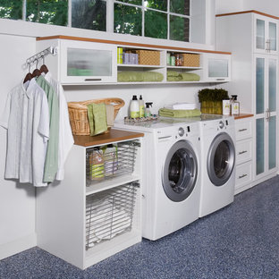 Design ideas for a medium sized contemporary single-wall utility room in New York with lino flooring, shaker cabinets, white cabinets, wood worktops, white walls, a side by side washer and dryer and brown worktops.