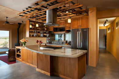 Inspiration for a galley open plan kitchen in Albuquerque with stainless steel appliances, concrete benchtops and medium wood cabinets.