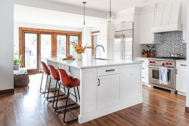 Kitchen - transitional brown floor and medium tone wood floor kitchen idea in Chicago with shaker cabinets, white cabinets, quartzite countertops, multicolored backsplash, stainless steel appliances, an island, white countertops and an undermount sink