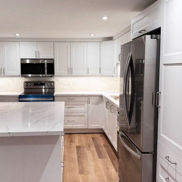 Bright White Transitional Kitchen with Quartz Peninsula and Full Slab Backsplash