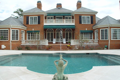 Example of a large classic backyard stone and custom-shaped aboveground pool design in Atlanta