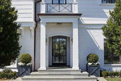 Modelo de fachada de casa blanca y gris clásica de tres plantas