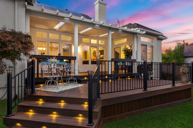 Inspiration for a mid-sized craftsman backyard ground level metal railing deck remodel in Sacramento with a pergola