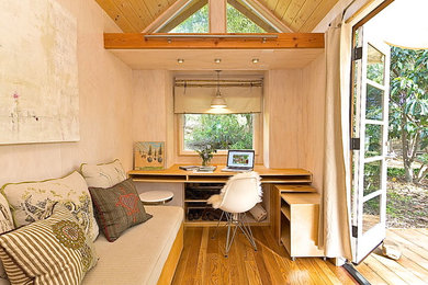 Small trendy built-in desk medium tone wood floor study room photo in Los Angeles with beige walls