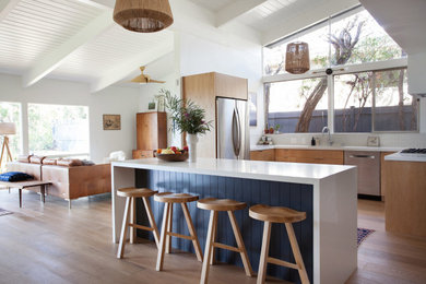 Mid-sized trendy u-shaped beige floor kitchen photo in Los Angeles with an undermount sink, flat-panel cabinets, medium tone wood cabinets, an island and white countertops