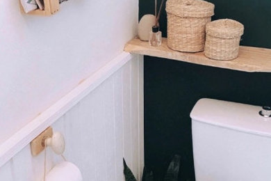 Cette image montre un WC et toilettes avec WC à poser, un mur vert, un sol en vinyl, un sol gris et boiseries.