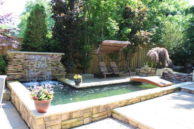 Patio - mid-sized transitional backyard patio idea in Toronto with a pergola