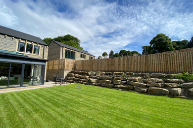 Exemple d'un jardin arrière tendance de taille moyenne et l'hiver avec une exposition partiellement ombragée, des pavés en pierre naturelle et une clôture en bois.