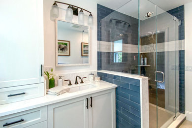 Transitional 3/4 blue tile and ceramic tile porcelain tile, gray floor and single-sink alcove shower photo in Boston with shaker cabinets, gray cabinets, a two-piece toilet, white walls, an undermount sink, quartz countertops, a hinged shower door, white countertops and a built-in vanity